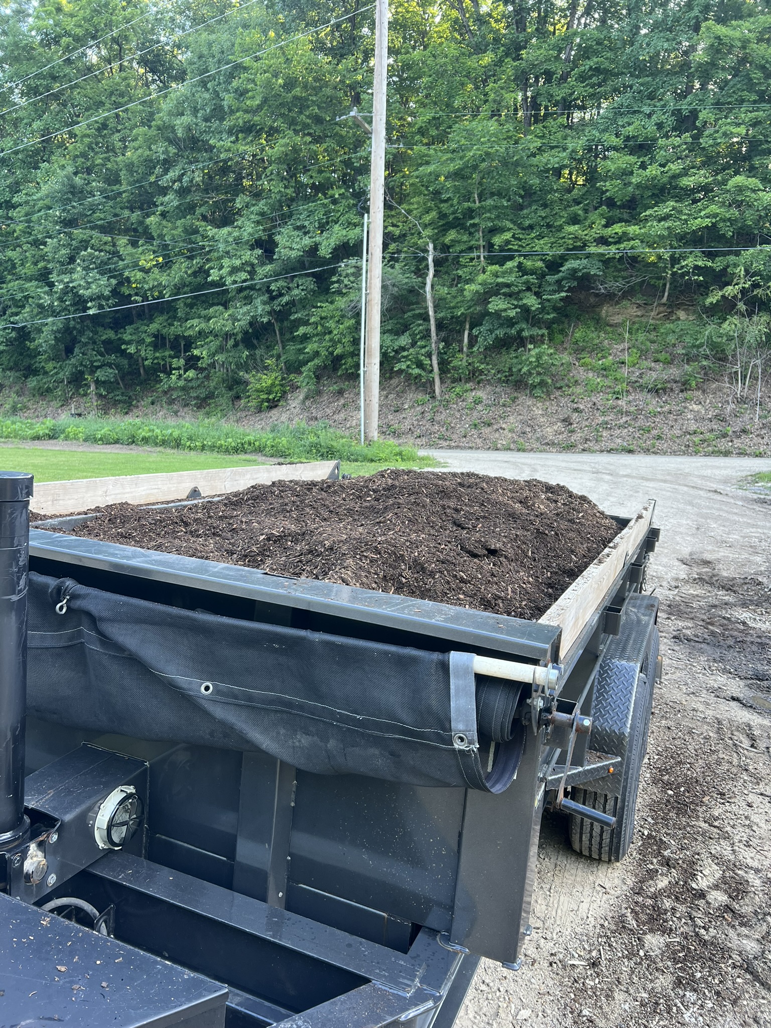 Diamond C dump trailer loaded with mulch showing full capacity