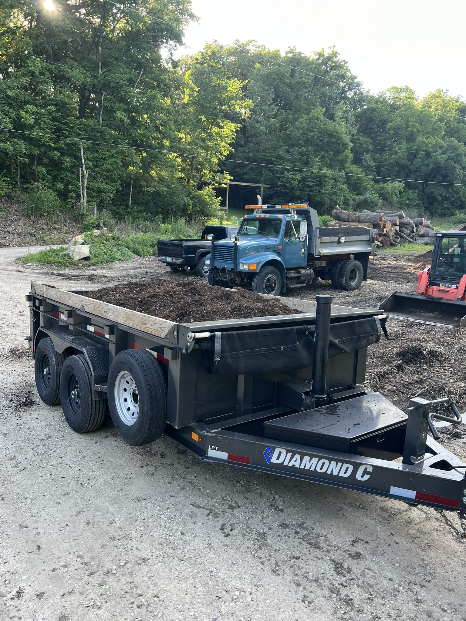Diamond C dump trailer loaded with mulch at a work site